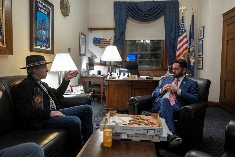 A couple of men sitting in chairsDescription automatically generated with low confidence