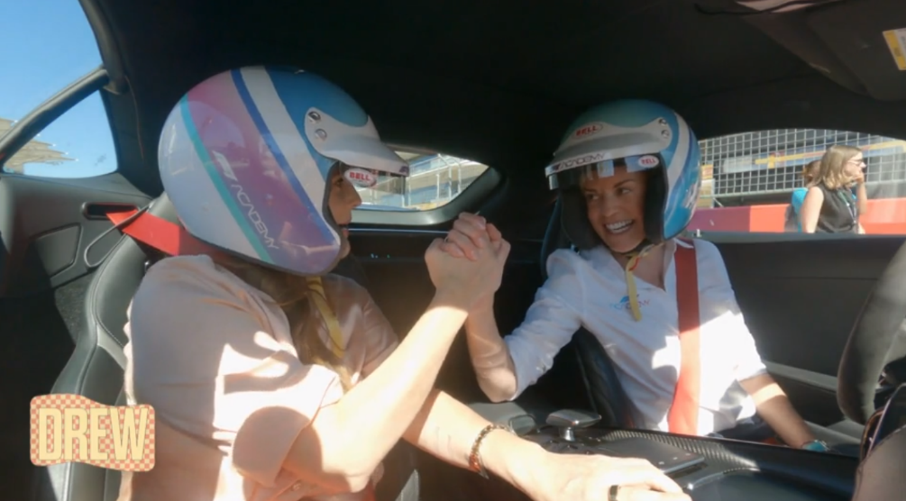 Two women wearing helmets in a carDescription automatically generated