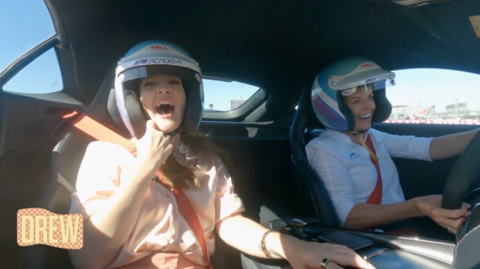 Two women wearing helmets in a carDescription automatically generated