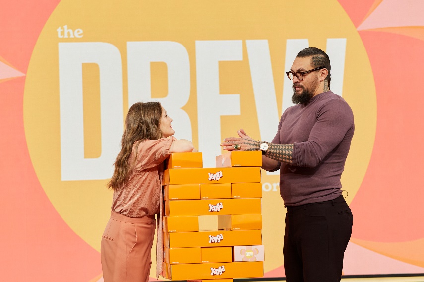 A person and person standing next to a stack of boxesDescription automatically generated