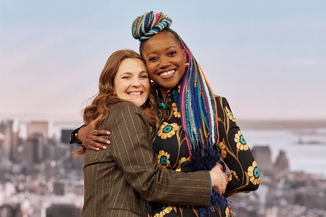 A couple of women huggingDescription automatically generated