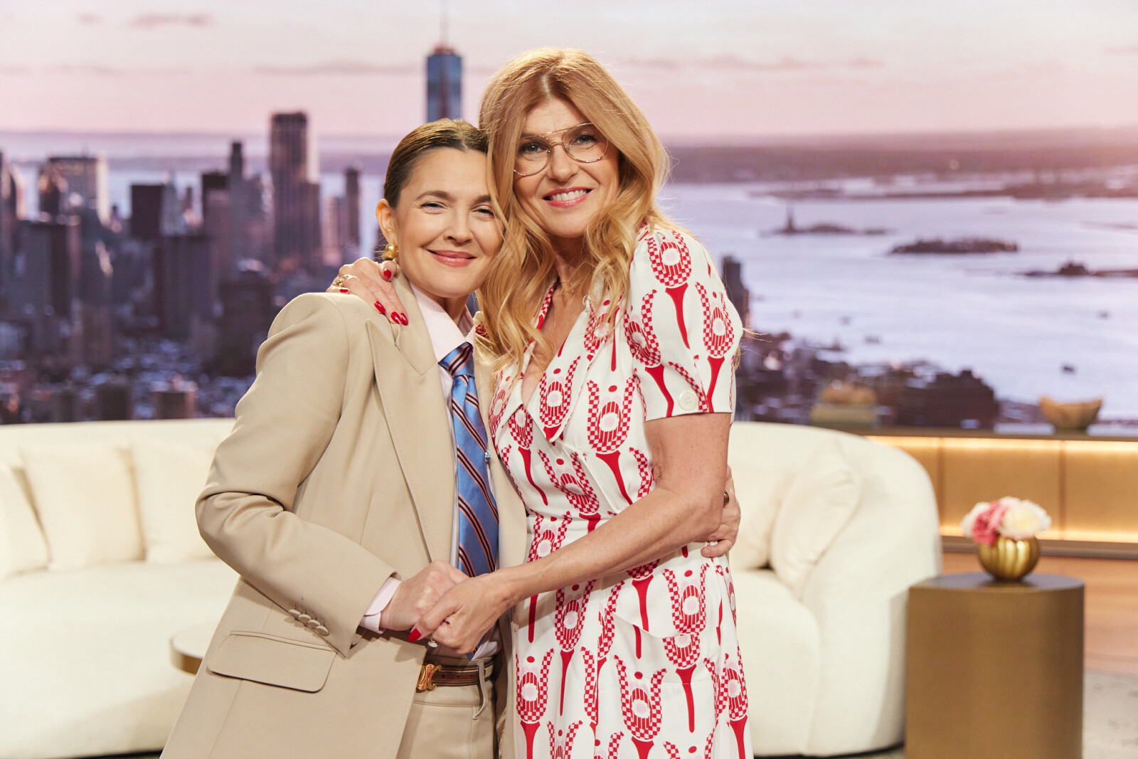 Two women in suits holding handsAI-generated content may be incorrect.