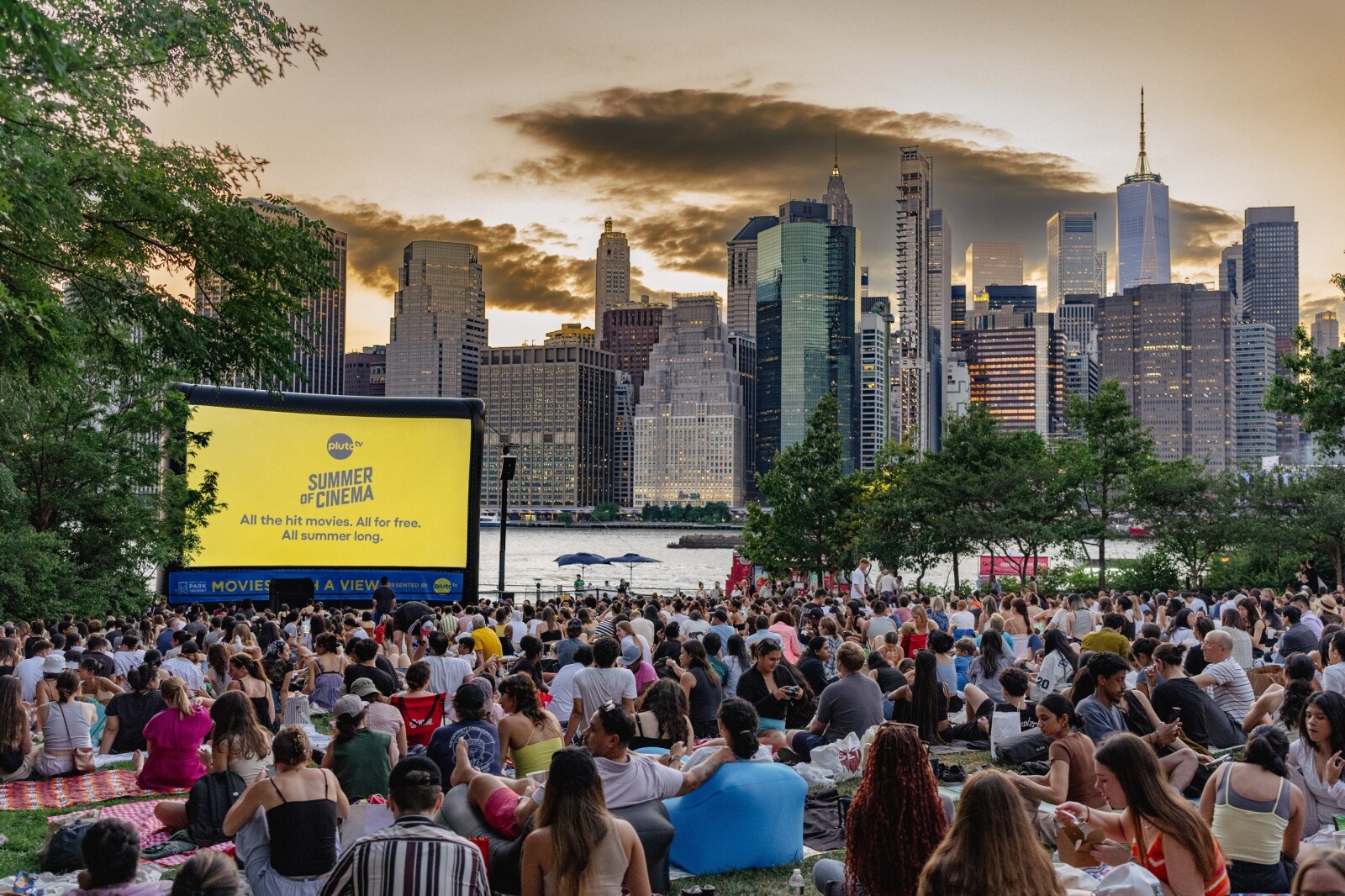 A large group of people sitting on the ground watching a movieAI-generated content may be incorrect.