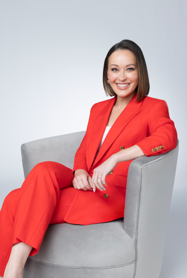 A person in a red suit sitting in a chairAI-generated content may be incorrect.
