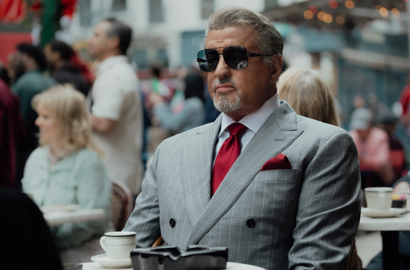 A person in a suit and sunglassesAI-generated content may be incorrect.