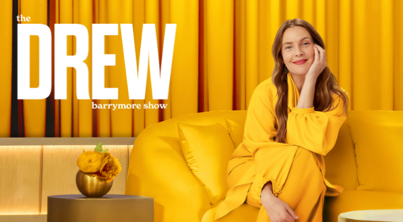 A person in a yellow dress sitting on a couchAI-generated content may be incorrect.
