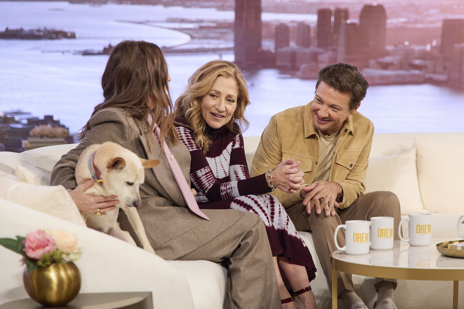 A group of people sitting on a couch with a dogAI-generated content may be incorrect.