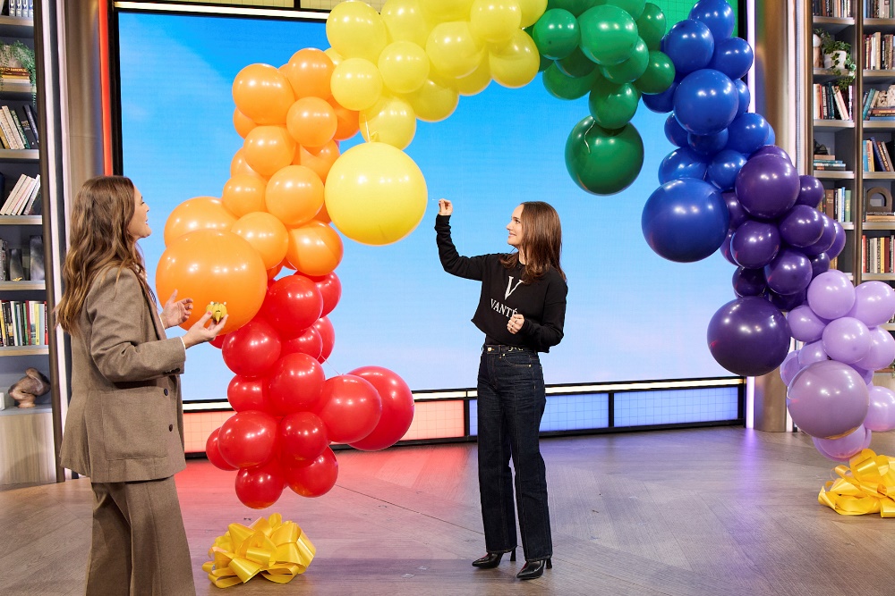 A person and person standing next to a balloon archAI-generated content may be incorrect.