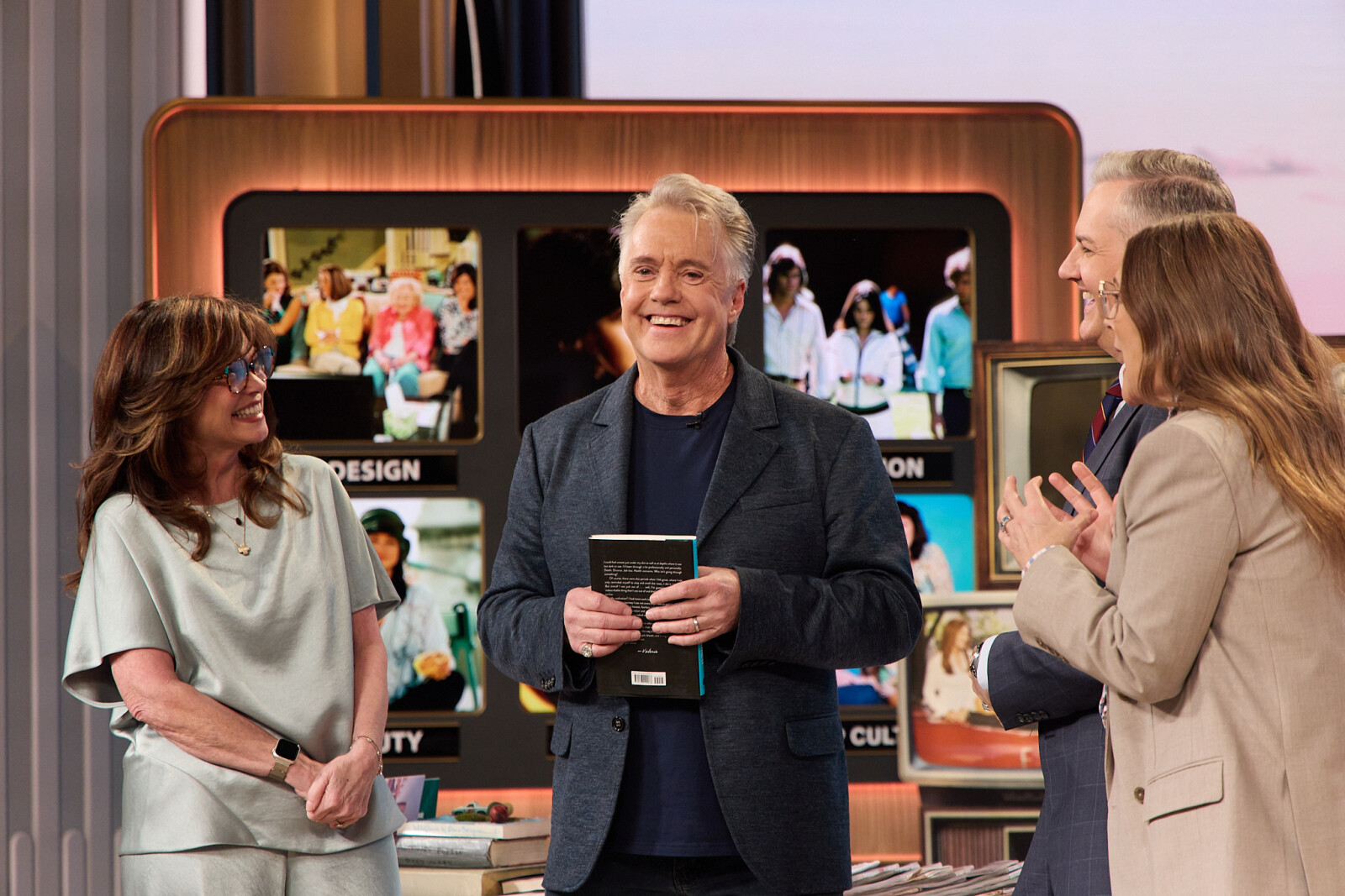 A group of people standing in front of a television screenAI-generated content may be incorrect.