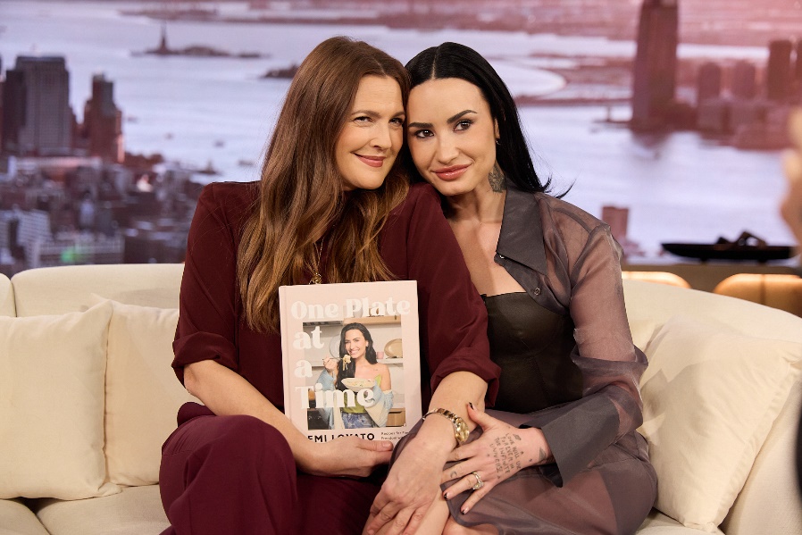 Two women sitting on a couchAI-generated content may be incorrect.