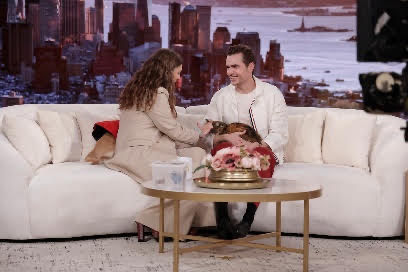 A person and person sitting on a couch with a dogDescription automatically generated